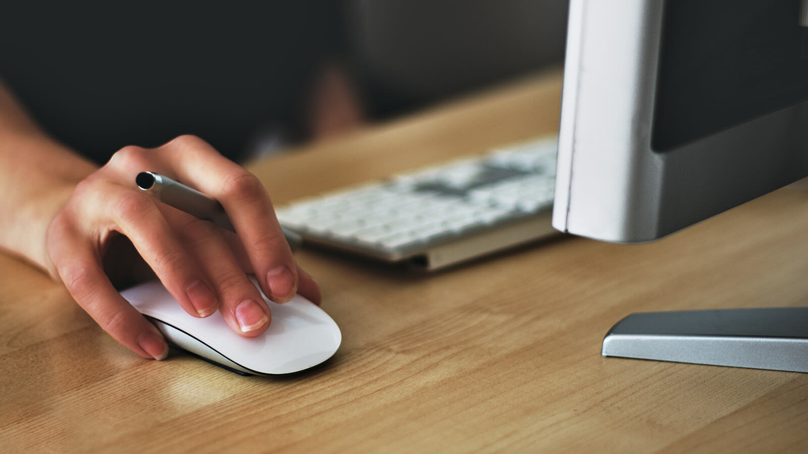 Close up of a person's hand on a computer mouse, getting ready to click.