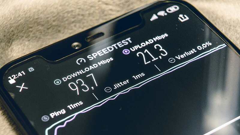 A mobile phone running an internet speed test, with the download and upload speeds displayed.