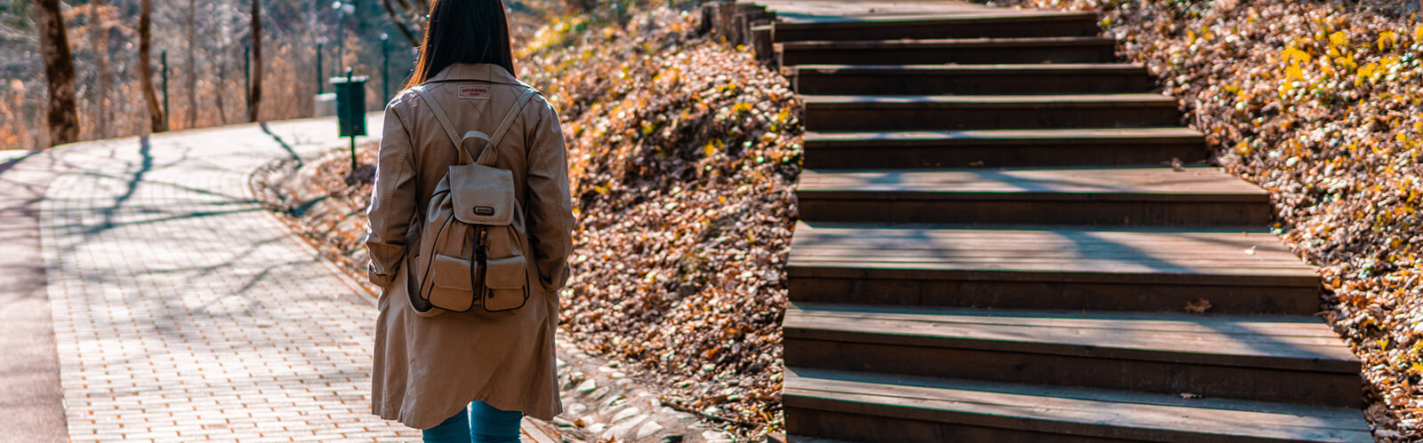 A person walking outside with two paths in front of them.